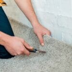 cropped view of installer holding cutter near carpet